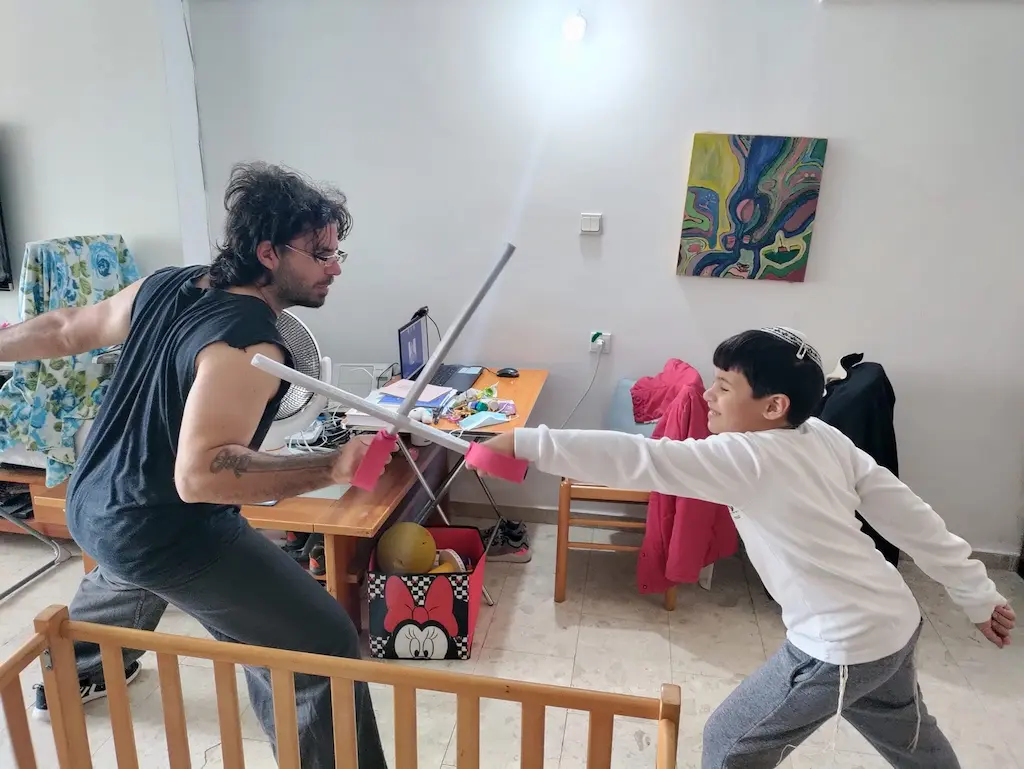 שחר יצחייק מתרגל חרב עם ילד